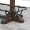 Wooden table base with metal railings on a gray floor. Homestead Pub Table available at Rustic Ranch Furniture and Decor.