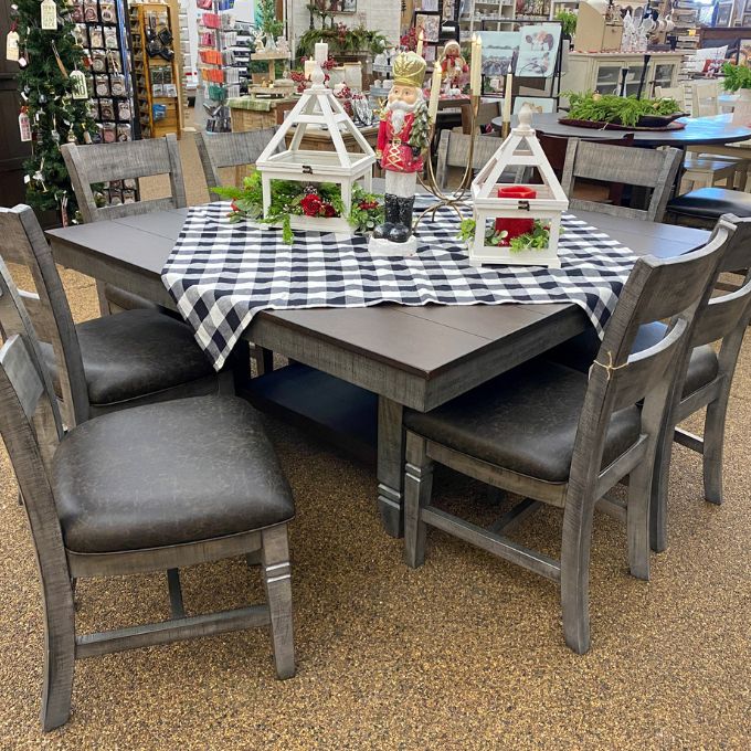 Dining table set with chairs and a checkered tablecloth in a store setting. Homestead Hills 60" Square Table available at Rustic Ranch Furniture and Decor.
