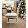 Wooden chair with a cushioned seat in a furniture store with a Christmas tree in the background.  Evy Ladderback Dining Chair available at Rustic Ranch Furniture and Decor.