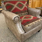 Brown armchair with patterned cushions on a carpeted floor. Charles Chair available at Rustic Ranch Furniture and Decor.