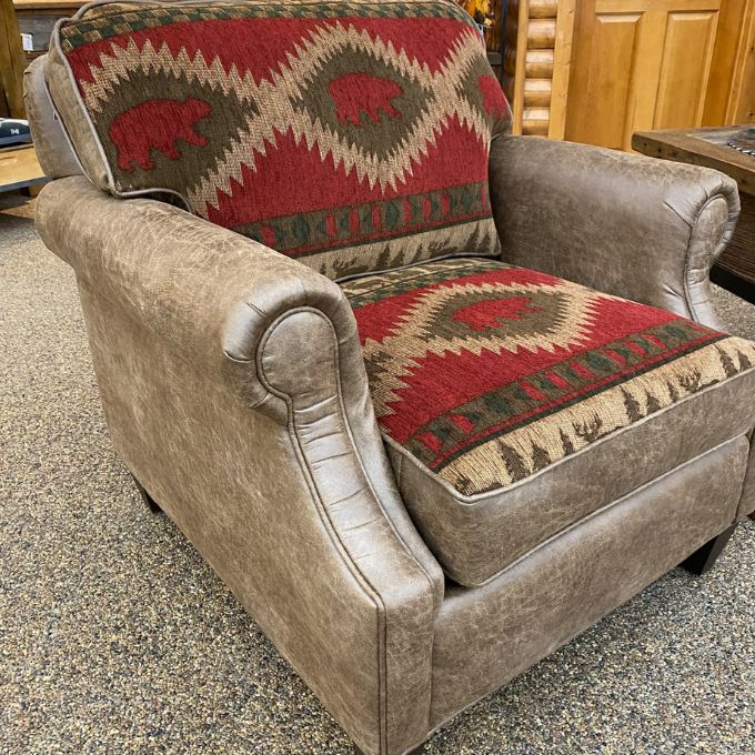 Brown armchair with patterned cushions on a carpeted floor. Charles Chair available at Rustic Ranch Furniture and Decor.