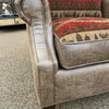 Brown upholstered chair with patterned cushion on a textured floor. Charles Chair available at Rustic Ranch Furniture and Decor.