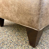 Close-up of a brown upholstered chair legs. Charles Chair and Ottoman available at Rustic Ranch Furniture and Decor.