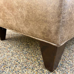 Close-up of a brown upholstered chair legs. Charles Chair and Ottoman available at Rustic Ranch Furniture and Decor.