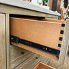 Open wooden drawer with visible hardware on a cabinet. Rowan Buffet available at Rustic Ranch Furniture and Decor.