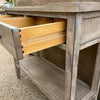 Wooden table with a drawer open, showing a rustic design. Beach Pebble Side Table available at Rustic Ranch Furniture and Decor.
