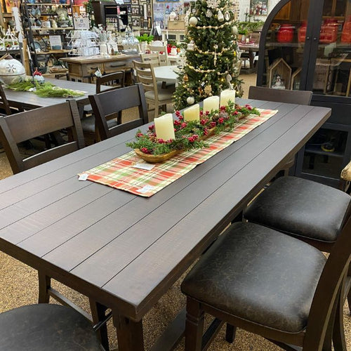 Dining table set with candles and a decorative centerpiece in a store setting. Homestead Pub Table available at Rustic Ranch Furniture and Decor.