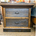 Wooden nightstand with two drawers on a textured surface. Fireside Nightstand available at Rustic Ranch Furniture and Decor.