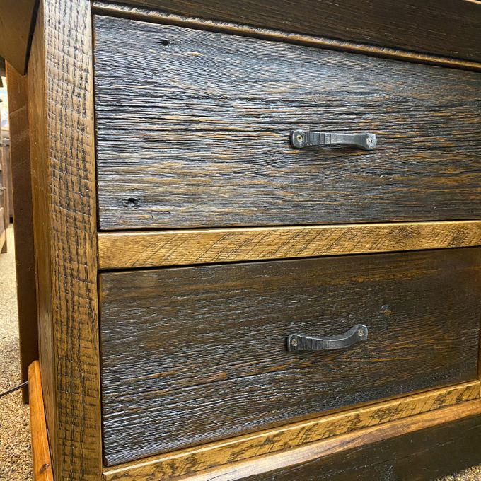 Wooden dresser with two drawers and metal handles on a textured surface. Fireside Nightstand available at Rustic Ranch Furniture and Decor.