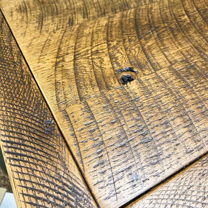 Close-up of wooden surface with visible grain and texture. Fireside Reclaimed Wood Seven Drawer Dresser available at Rustic Ranch Furniture and Decor.