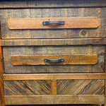 Wooden drawer with two handles on a rustic wooden surface. Jackson Hole Reclaimed Wood Nightstand available at Rustic Ranch Furniture and Decor.