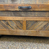 Wooden surface with a metal handle on a textured background. Jackson Hole Reclaimed Wood Nightstand available at Rustic Ranch Furniture and Decor.