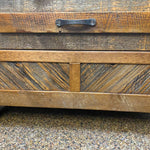Wooden surface with a metal handle on a textured background. Jackson Hole Reclaimed Wood Nightstand available at Rustic Ranch Furniture and Decor.