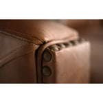 Close-up of brown leather furniture with button details.  The Hollister Sofa is  available at Rustic Ranch Furniture and Decor.