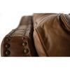 Close-up of a brown leather furniture with button details on a white background.  The Hollister Sofa available at Rustic Ranch Furniture and Decor.