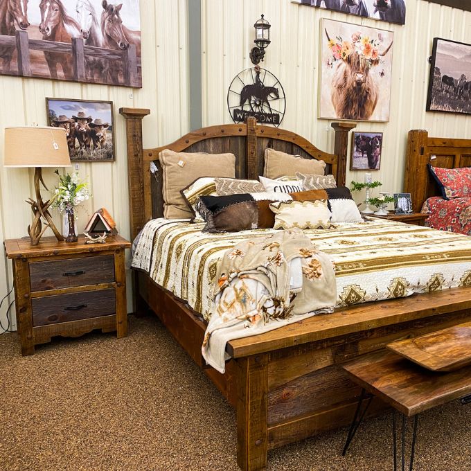 Bedroom with wooden furniture, including a bed and nightstands, with decorative elements like pillows and lamps. Black Hills Two Drawer Nightstand available at Rustic Ranch Furniture and Decor.