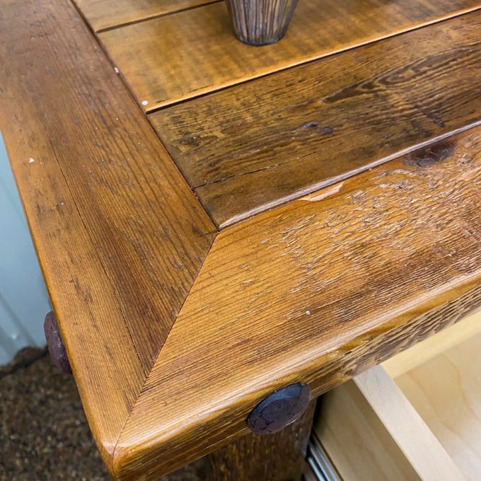Close-up of a wooden table with a rustic finish. Black Hills Two Drawer Nightstand available at Rustic Ranch Furniture and Decor.