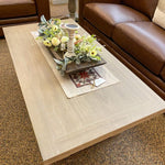 Coffee table with decorative items in a living room setting. Gianna Coffee Table available at Rustic Ranch Furniture and Decor.