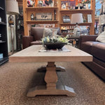 Wooden coffee table table with a decorative arrangement in a room with furniture and decor. Gianna Coffee Table available at Rustic Ranch Furniture and Decor.