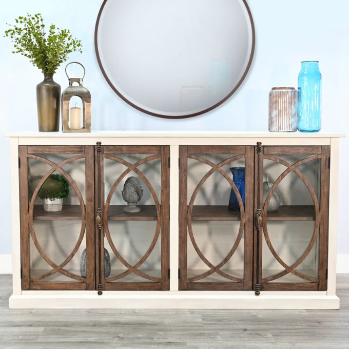 Wooden sideboard with glass doors and decorative items against a light blue wall. Pasadena Media Console - 78" available at Rustic Ranch Furniture and Decor.