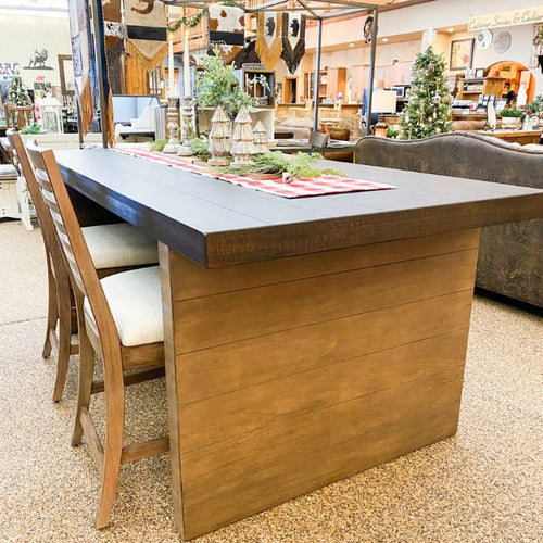 Wooden dining table with chairs in a showroom setting. Boise Counter Table available at Rustic Ranch Furniture and Decor.