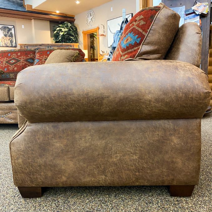 Brown leather sofa with patterned cushions in a store setting.  Emerson Chair and a Half available at Rustic Ranch Furniture and Decor.