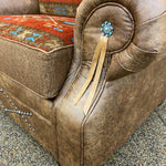 Brown leather chair with decorative elements on a textured surface.  Emerson Chair and a Half available at Rustic Ranch Furniture and Decor.