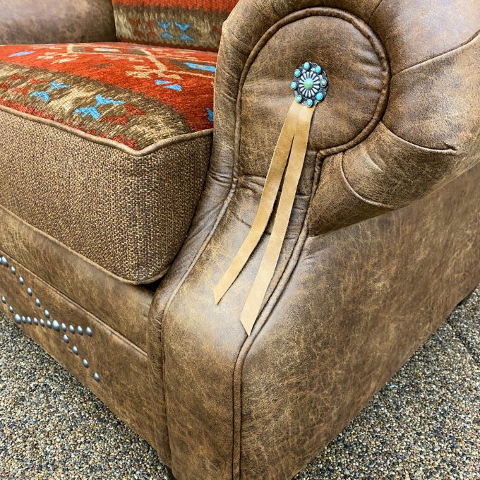Brown leather chair with decorative elements on a textured surface.  Emerson Chair and a Half available at Rustic Ranch Furniture and Decor.
