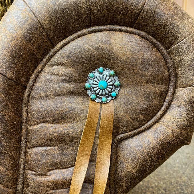 Leather concho featuring turquoise stones on a textured brown leather background.  Emerson Chair and a Half available at Rustic Ranch Furniture and Decor.