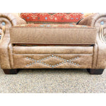 Brown leather chair and a half with decorative studs on a textured surface. Emerson Chair and a Half available at Rustic Ranch Furniture and Decor.