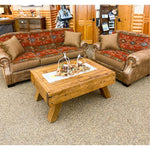 A patterned sofa and a chair with a wooden coffee table in a room with wooden walls.  Emerson Chair and a Half available at Rustic Ranch Furniture and Decor.