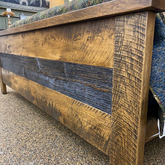 Wooden headboard with a rustic finish on a carpeted floor.  Fireside bed available at Rustic Ranch Furniture and Decor.