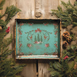 Decorative tray with floral and nature-themed design on a wooden background with greenery. La Folie Paint Inlay by IOD - Limited Edition available at Rustic Ranch Furniture and Decor.