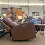 Brown recliner love seat in a showroom setting with various decor items on the walls.  Vienna Reclining Love Seat available at Rustic Ranch Furniture and Decor.
