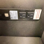 Black power strip with multiple outlets on a dark textured surface.  Vienna Reclining Love Seat available at Rustic Ranch Furniture and Decor.