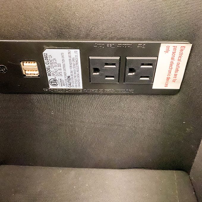 Black power strip with multiple outlets on a dark textured surface.  Vienna Reclining Love Seat available at Rustic Ranch Furniture and Decor.