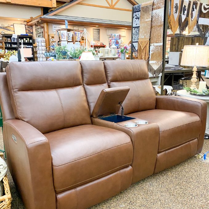 Brown leather recliner love seat with cup holders in a store setting.  Vienna Reclining Love Seat available at Rustic Ranch Furniture and Decor.