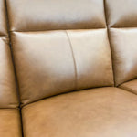 Close-up of a brown leather sofa seat.  Vienna Reclining Love Seat available at Rustic Ranch Furniture and Decor.