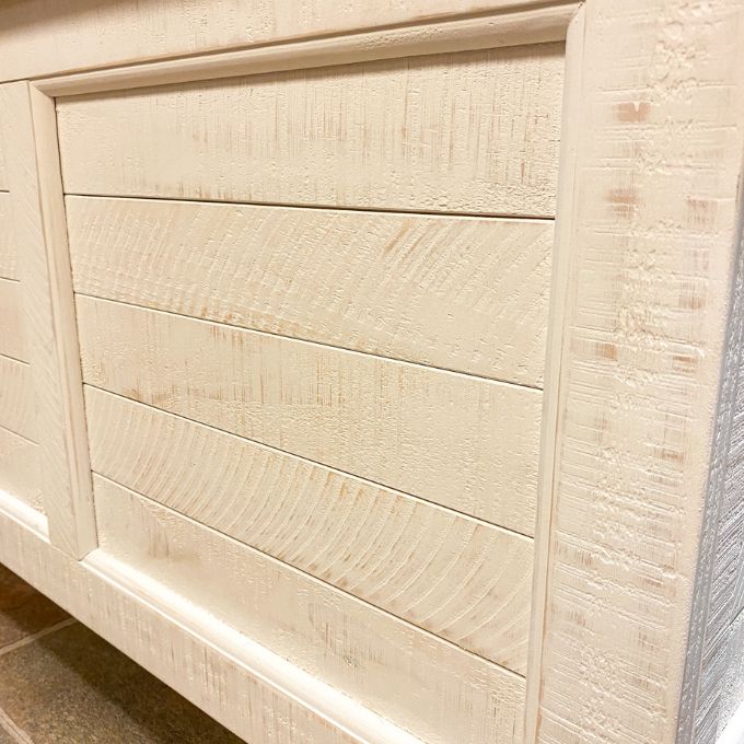 Close-up of a wooden storage chest with a textured finish. White Dashbury Storage Trunk available at Rustic Ranch Furniture and Decor.