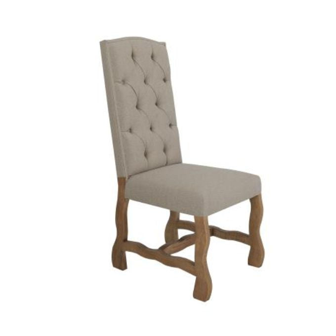 Beige upholstered chair with wooden legs on a white background. Marquez Dining chair available at Rustic Ranch Furniture and Decor.