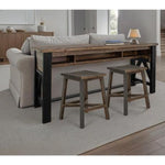 Wooden sofa table with black legs and two stools in a living room setting. Loft Brown Counter Height Sofa Table available at Rustic Ranch Furniture and Decor.
