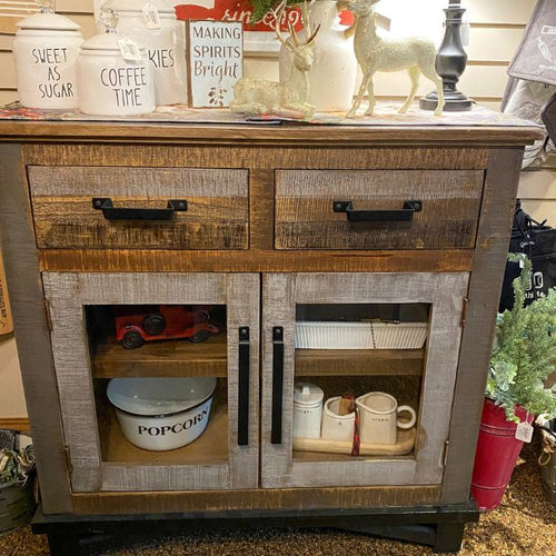 Wooden sideboard with decorative items including a 'Popcorn' bowl and small figurines. Loft Brown Server - Cabinet available at Rustic Ranch Furniture and Decor.